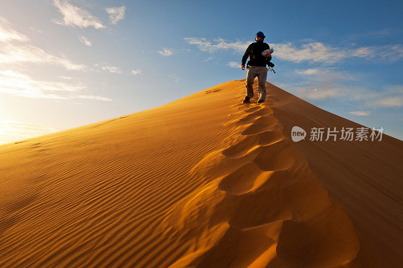 在非洲摩洛哥日出的Erg Chebbi沙丘上的人